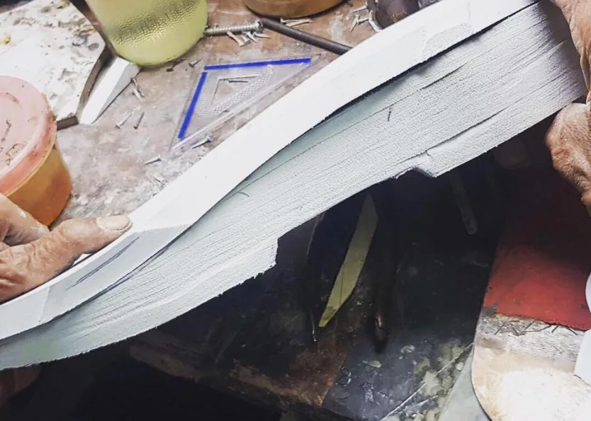 Layers of white EVA being shaped into the sole