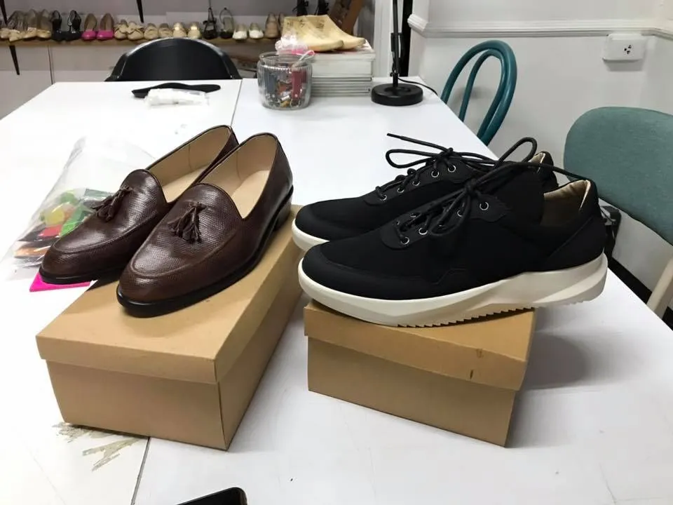 Loafers and sneakers on shoeboxes at the workshop