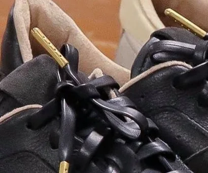 Close-up of black leather laces with gold aglets