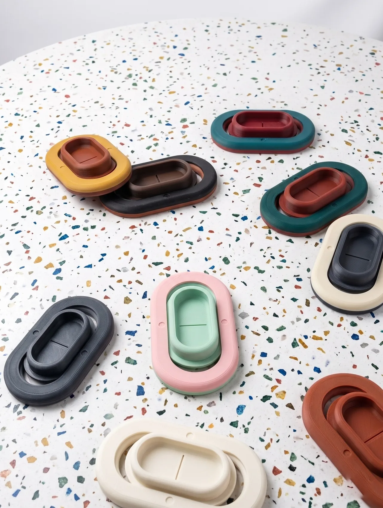Pocket Wrestler units in black, cream, mint, pink and rust on a terrazzo surface