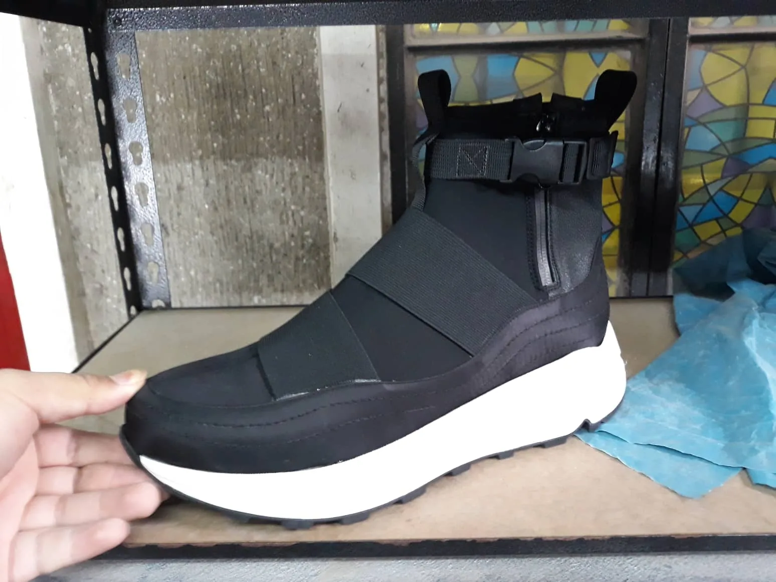 Black sample on a molded white sole, held on a workshop shelf
