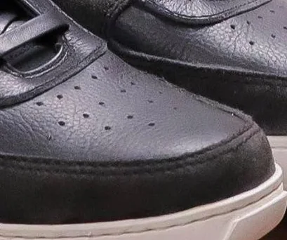 Close-up of the perforated toe and suede mudguard on the black pair