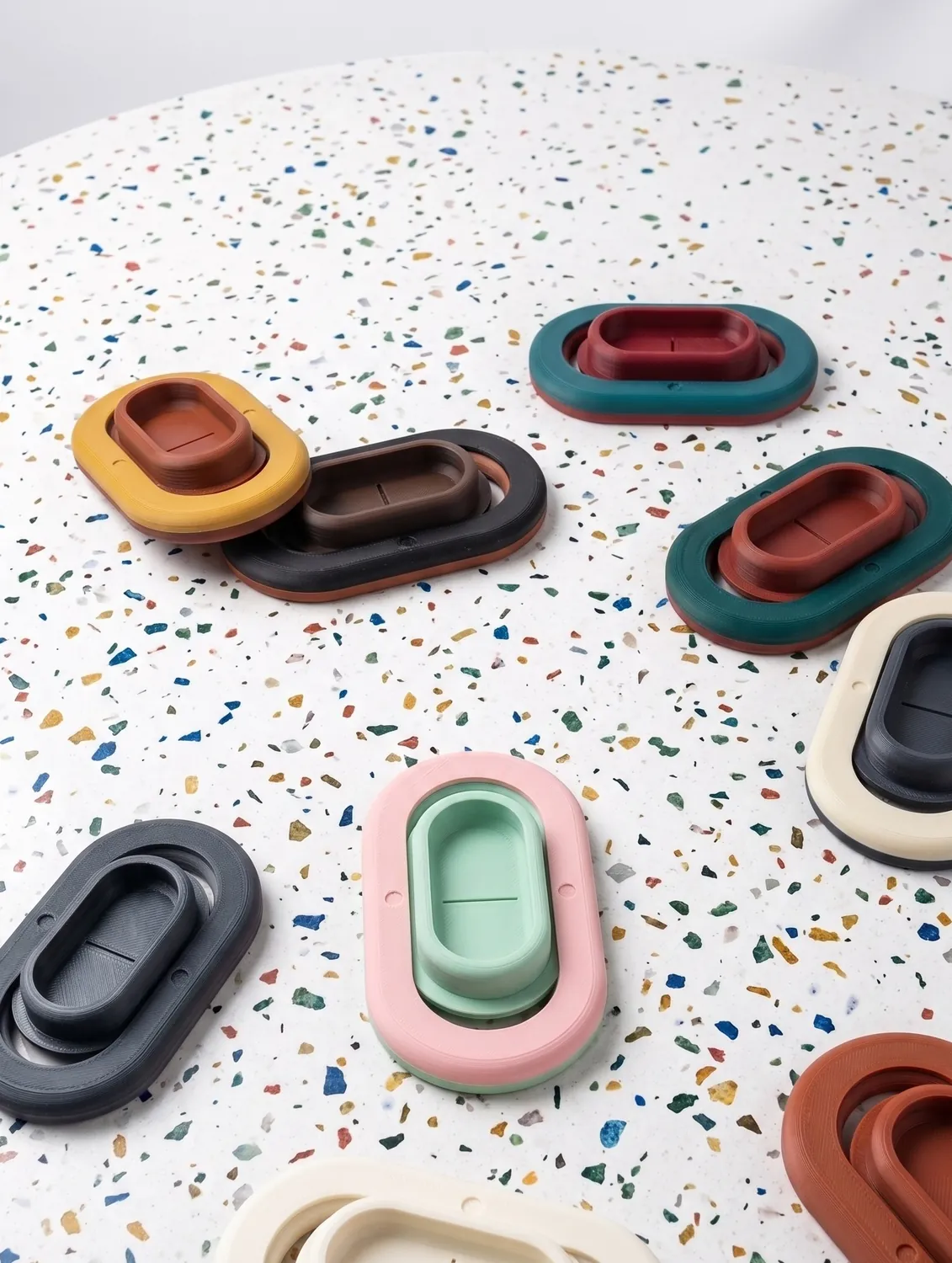 Pocket Wrestler units in black, cream, mint, pink and rust on a terrazzo surface